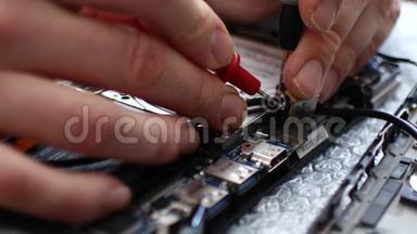 工程师在笔记本电脑上焊接电源连接器。 笔记本电脑维修保养